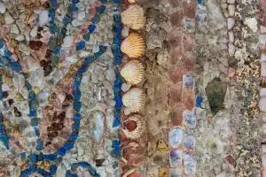 A close-up photo showing the rocks, shells and other materials used in the mosaic.