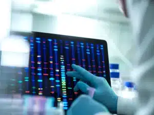 Scientist examining DNA (deoxyribonucleic acid) results on a screen during an experiment in the laboratory.