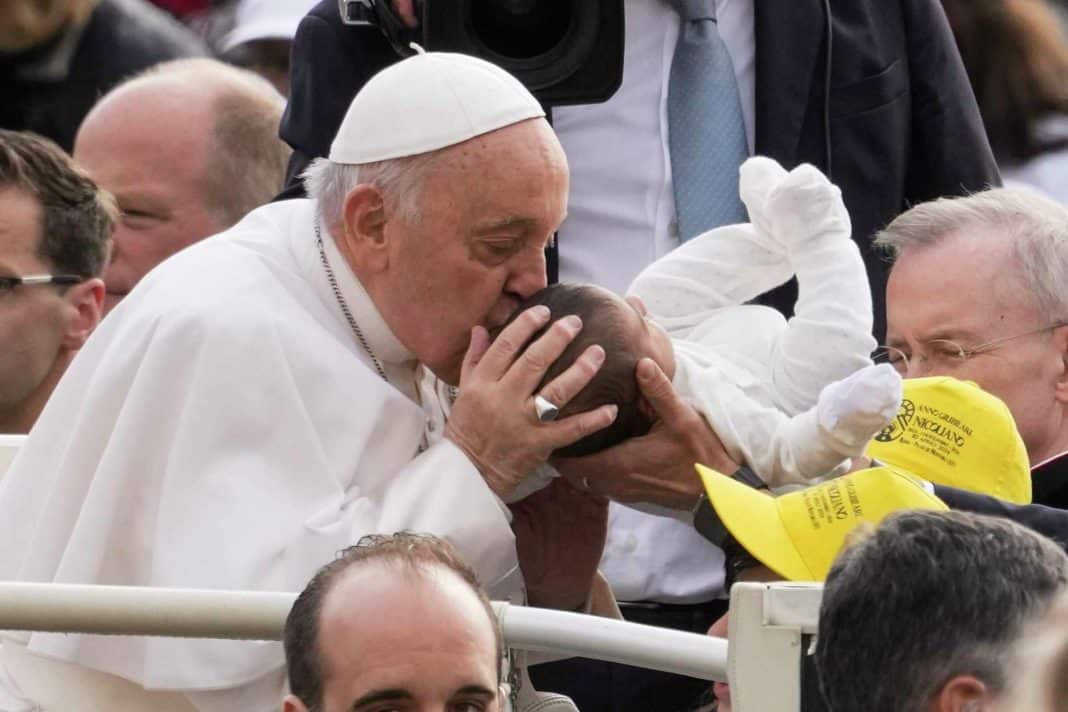 Pope Francis kisses a new born as he arrives for his weekly general audience in St. Peter's Square at The Vatican, Wednesday, April 10, 2024. Andrew Medichini/AP