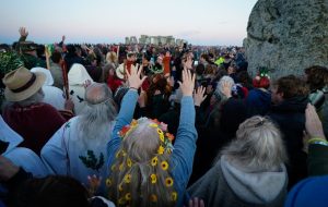 People gather around the Heel Stone ahead of sunrise as they take part in the summer solstice at Stonehenge (Andrew Matthews/PA)