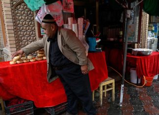 China Changed Names Of 630 Village ‘To Erase Uyghur Culture’ In Northwest Xinjiang: Report This picture taken on July 19, 2023 shows a Uyghur food vendor tending to his stall in Artux, northwestern China's Xinjiang region. (Photo by Pedro PARDO / AFP)