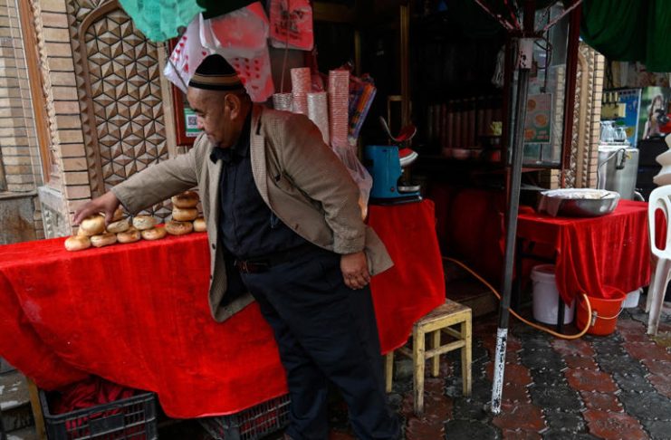 This picture taken on July 19, 2023 shows a Uyghur food vendor tending to his stall in Artux, northwestern China's Xinjiang region. (Photo by Pedro PARDO / AFP)