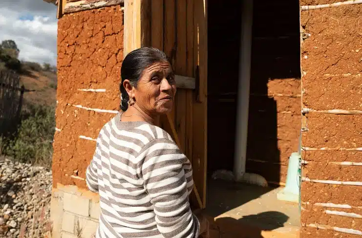 Sofia Aguilar, 63, enters her daughter’s composting bathroom, constructed with adobe walls, in the Xixovo community on 5 December 2023 (Credit: Stephania Corpi Arnaud)