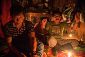 Shaman Cesar Ampuero conducts the ayahuasca ceremony with local villagers in Yarinacocha, Peru. During the ritual, participants will smoke black tobacco cigarettes called mapachos and perform traditional sings know as Icaros, to call for support of the spirits.Image: Manuel Medir / Getty Images
