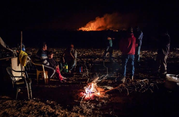 Guarani-Kaiowa Indigenous people, who are reclaiming land, stand in a camp during a conflict with men backed by farmers in trucks and tractors in Douradina district, state of Mato Grosso do Sul, Brazil August 3, 2024. REUTERS/Gabriel Schlickmann